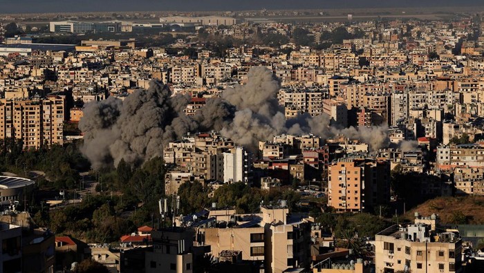 A Lebanese Middle East Airlines (MEA) aircraft flies over Beirut's southern suburbs as it approaches Beirut-Rafic Hariri International Airport, amid the ongoing hostilities between Hezbollah and Israeli forces, as seen from Baabda, Lebanon, November 21, 2024. REUTERS/Thaier Al-Sudani