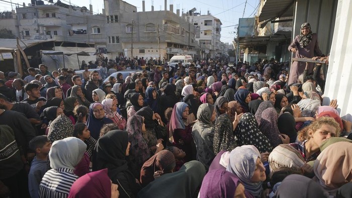 Warga Gaza Berdesakkan demi Dapat Seplastik Roti A crowd gathers in front of a bakery to get a share of bread in Deir al-Balah, Gaza Strip, Thursday Nov. 21, 2024. Some bakeries in the Gaza Strip have reopened Thursday morning after shuttering for several days due to a flour shortage and lack of food aid.(AP Photo/Abdel Kareem Hana)