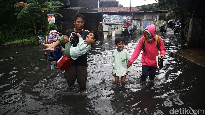 Warga menerobos banjir yang merendam Jl Hamka, Larangan, Kota Tangerang, Banten, Jumat (22/11/2024). Banjir diakibatkan anak sungai yang melintasi jalan tersebut meluap setelah hujan deras sekitar 90 menit pada Jumat sore.