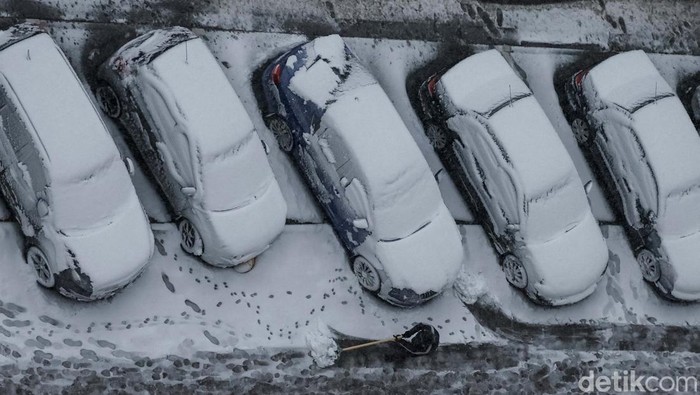 Warga Ukraina Hadapi Musim Dingin dan Serangan Rusia A worker cleans a street where cars are covered in snow amid the first snowfall, amid Russia's attack on Ukraine, in Kyiv, Ukraine November 21, 2024. REUTERS/Gleb Garanich TPX IMAGES OF THE DAY