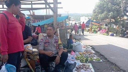 Bripka Agustinus Fay saat berinteraksi dengan warga.