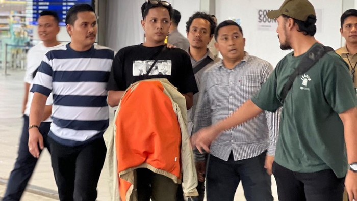 Pelaku penganiayaan mantan pacar berinisial NM saat diamankan oleh polisi di Bandara Hang Nadim Batam. (dok. Istimewa)