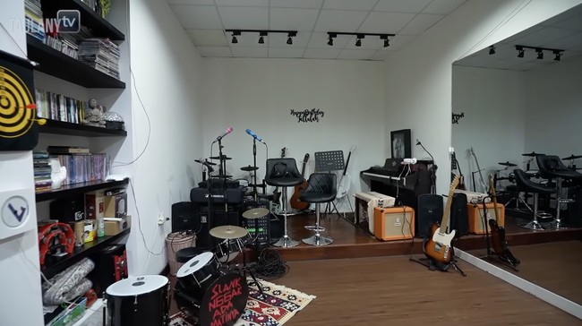 Di dalam rumah, terdapat sebuah ruangan besar multifungsi. Bimbim biasanya memanfaatkan area yang dilengkapi berbagai alat musik tersebut untuk latihan atau jamming. (Foto: YouTube/Taulany TV)