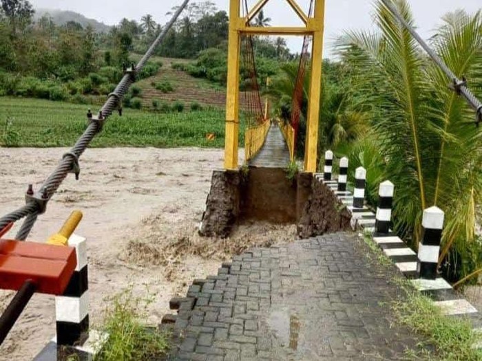 Badan jalan dekat jembatan Desa Kaliguwo-Kalidadap di Kabupaten Wonosobo longsor diterjang banjir Sungai Luk Ulo, Minggu (24/11/2024).