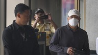 Rohidin Mersyah tampak menutupi mukanya dengan masker.