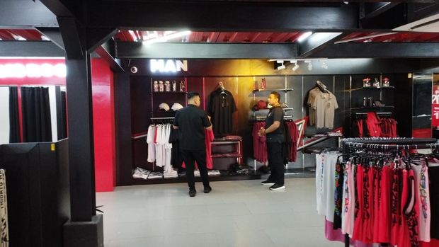 Pegawai Bali United Megastore, Tude Copo (kanan), saat melayani pengunjung, Sabtu (16/11/2024).