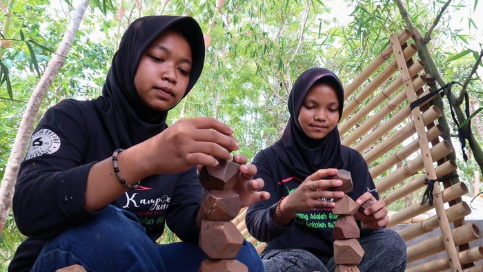 Pelestarian permainan tradisional Anak-anak bermain permainan tradisional pateng dudu di Kampung Baca Taman Rimba (Batara) Banyuwangi, Jawa Timur, Minggu (24/11/2024). Kegiatan edukasi yang diisi dengan berbagai permainan tradisional tersebut dalam rangka melestarikan permainan tradisional dan mengasah ketangkasan serta meningkatkan interaksi pergaulan antar anak sehingga diharapkan dapat mengurangi penggunaan gawai yang populer dikalangan anak-anak. ANTARA FOTO/Budi Candra Setya/agr *** Local Caption ***