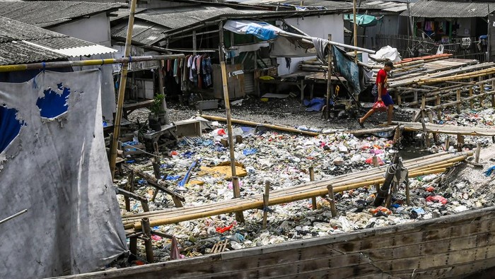 Warga berjalan di tanggul laut Kampung Dadap yang dipenuhi sampah di Kosambi, Kabupaten Tangerang, Banten, Minggu (24/11/2024). Kesatuan Perempuan Pesisir Indonesia (KPPI) meminta pemerintah setempat menuntaskan masalah penanganan sampah di Kampung Dadap Tangerang dengan menyediakan layanan pengelolaan sampah untuk meningkatkan kebersihan dan kesehatan lingkungan. ANTARA FOTO/Sulthony Hasanuddin/agr