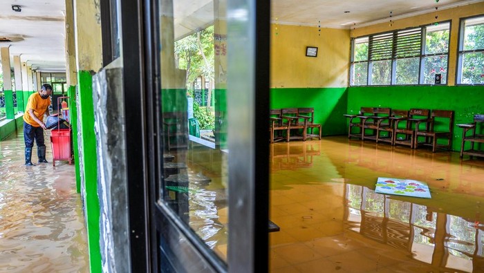 Sekolah terdampak banjir di Kabupaten Bandung Penjaga sekolah memeriksa lorong sekolah yang terdampak banjir di SMPN 1 Bojongsoang, Kabupaten Bandung, Jawa Barat, Minggu (24/11/2024). Penjaga sekolah mengungkapkan sejak Jumat (22/11/2024) sekolah tersebut terendam banjir akibat intensitas hujan yang tinggi dan luapan Sungai Citarum dan fasilitas sekolah tidak dapat digunakan karena debit air yang masih tinggi. ANTARA FOTO/Raisan Al Farisi/agr