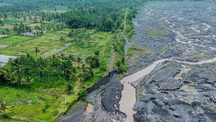 Foto udara kondisi tanggul yang rusak akibat banjir di Desa Gondoruso, Lumajang, Jawa Timur, Minggu (24/11/2024). Tanggul penahan banjir lahar hujan Gunung Semeru sepanjang 275 meter tersebut rusak dan tak kunjung diperbaiki selama delapan bulan terakhir. ANTARA FOTO/Irfan Sumanjaya/agr