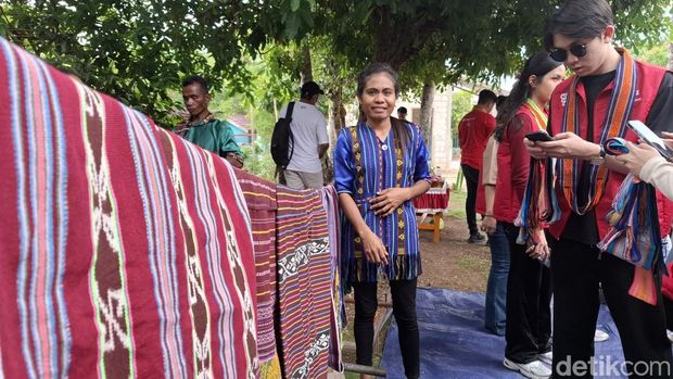 Yuliana Nesi (26) saat mengajari cara menenun kepada pengunjung di rumahnya di Kelurahan Naioni, Kecamatan Alak, Kota Kupang, NTT. (Yufengki Bria/detikBali)