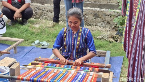 Yuliana Nesi (26) saat mengajari cara menenun kepada pengunjung di rumahnya di Kelurahan Naioni, Kecamatan Alak, Kota Kupang, NTT. (Yufengki Bria/detikBali)