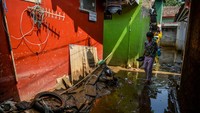 Seorang anak berjalan melewati lumpur bercampur air pascabanjir akibat tanggul jebol di Desa Citeureup, Kecamatan Dayeuhkolot, Kabupaten Bandung, Jawa Barat, Senin (25/11/2024). 