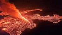 Foto-foto diam yang diambil dari penerbangan oleh pihak berwenang di atas area tersebut memperlihatkan intensitas letusan, saat lava merah jingga menyembur dari celah panjang yang dikelilingi asap tebal menerangi langit malam. 