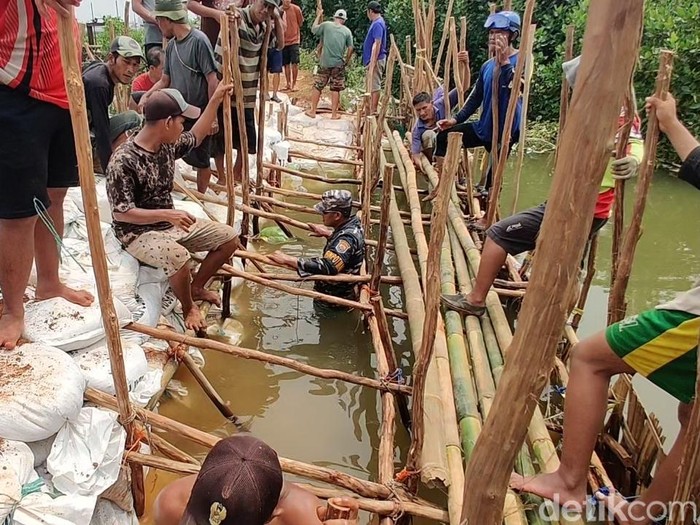 Gotong royong menambal tanggul jebol di Sungai Bremi, Kabupaten Pekalongan, Senin (25/11/2024) sore.