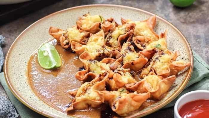 batagor, abbreviated from Bakso Tahu Goreng, is meatball dough put into tofu, dumpling skin, or made into balls then fried. served on a serving plate with peanut sauce, chili sauce, and sauce. It is authentic street food from Bandung, West Java, Indonesia.