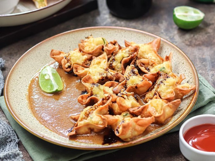 batagor, abbreviated from Bakso Tahu Goreng, is meatball dough put into tofu, dumpling skin, or made into balls then fried. served on a serving plate with peanut sauce, chili sauce, and sauce. It is authentic street food from Bandung, West Java, Indonesia.