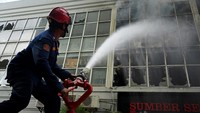 Petugas berupaya memadamkan api yang membakar toko sepeda di kompleks Ramayana Jalan AP Pettarani, Makassar, Sulawesi Selatan, Senin (25/11/2024). 