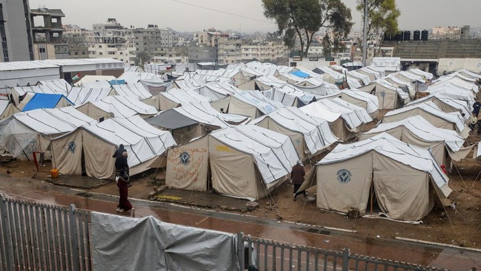 A Displaced Palestinian man stands in front of a tent following rainfall, amid the Israel-Hamas conflict, in Gaza City November 24, 2024. REUTERS/Dawoud Abu Alkas
