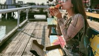 Berkunjung ke salah satu pasar tradisional di luar negeri, Natasha makan siang dengan sepotong pizza yang digemarinya. Foto: Instagram @natashawilona12