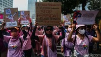 Para aktivis perempuan ini mengenakan pakaian serba pink dan ungu. 