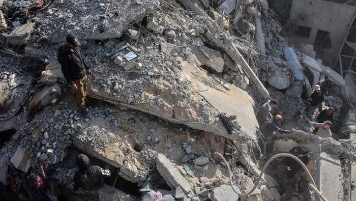 A Palestinian rescuer checks the rubble of a building in the aftermath of an Israeli strike south of Gaza City on November 22, 2024, as the war between Israel and Hezbollah continues. (Photo by Omar AL-QATTAA / AFP)