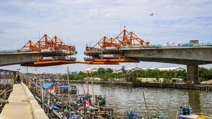 Nelayan melintas menggunakan perahu di dekat proyek pembangunan Jalan Tol Kamal-Teluknaga-Rajeg atau Tol PIK 2 di Kosambi, Kabupaten Tangerang, Banten, Minggu (24/11/2024). Jalan tol yang menghubungkan Tol Sedyatmo dan kawasan Pantai Indah Kapuk (PIK) 2 sepanjang 38,60 kilometer dengan anggaran Rp23 triliun tersebut direncanakan beroperasi pada Kuartal I/2025. ANTARA FOTO/Sulthony Hasanuddin/agr