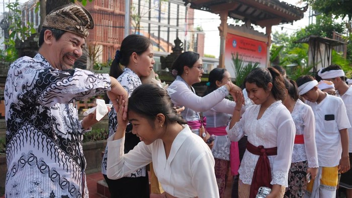 Peringatan Hari Guru di Bali Siswa memberikan bunga kepada gurunya saat perayaan peringatan Hari Guru di SMP Negeri 1 Denpasar, Bali, Senin (25/11/2024). Kegiatan yang mengusung tema Guru Hebat, Indonesia Kuat tersebut sebagai ungkapan rasa kasih sayang dan terima kasih dari murid kepada guru dalam memperingati Hari Guru Nasional 2024. ANTARA FOTO/Nyoman Hendra Wibowo/tom.
