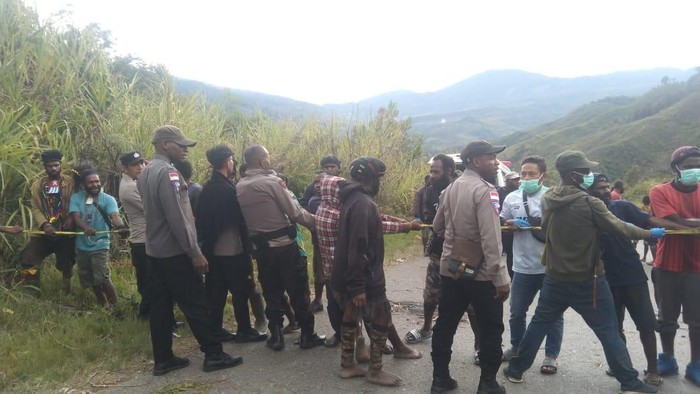 Polisi dan warga menarik truk terbalik dari dalam parit di Tolikara. Dokumen Istimewa