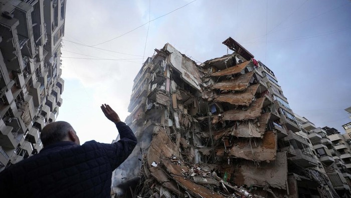 Potret Kawasan di Beirut Hancur Diserang Israel A woman uses her mobile phone as she stands near damaged buildings, in the aftermath of Israeli strikes on Beirut's southern suburbs, amid the ongoing hostilities between Hezbollah and Israeli forces, Lebanon November 25, 2024. REUTERS/Mohammed Yassin