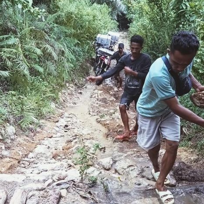 Sepeda motor melewati jalan rusak angkut logistik Pilkada 2024 ke Desa Romang, Kecamatan Macang Pacar, Manggarai Barat, Nusa Tenggara Timur (NTT), Senin (25/11/2024). (Istimewa)