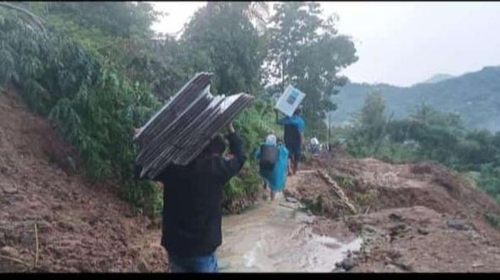 Tangkapan layar petugas pikul logistik pemilu akibat truk pengangkut terjebak longsor di Kecamatan Kuwus, Manggarai Barat, NTT, Senin (25/11/2024). (Istimewa)