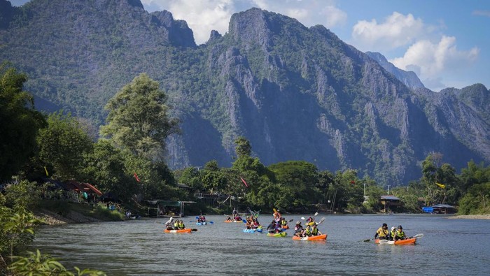 Seorang turis asing melompat ke dalam air di Blue Lagoon, di Vang Vieng, Laos