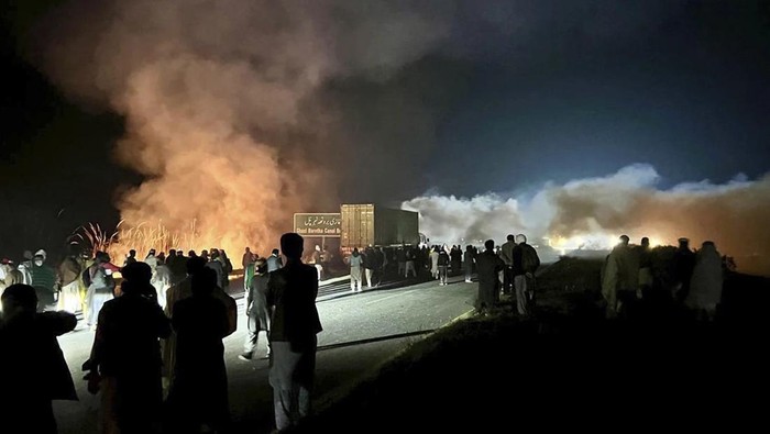 Demonstran membakar semak-semak untuk mengurangi efek gas air mata yang ditembakkan polisi Pakistan. (AP Photo/Maaz Awan)