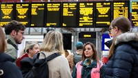 Seorang karyawan Great Western Railway berbicara kepada penumpang kereta api setelah pembatalan kereta yang disebabkan oleh Badai Bert di Stasiun Paddington di London, Inggris, Senin (25/11/2024).