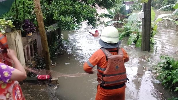 Petugas BPBD mengevakuasi warga yang terjebak di atap rumahnya saat banjir 3 meter merendam kediamannya. Foto: Dok. Istimewa