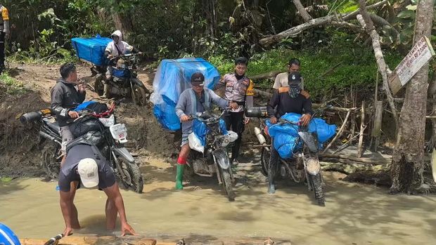 Petugas menggunakan motor melewati jalan terjal selama 6 jam