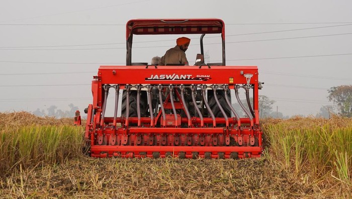 Potret Petani India Adopsi Metode Ramah Lingkungan untuk Melawan Polusi Farmers use a baler machine to make paddy straw bales from leftover stubble in a rice field amid the ongoing air pollution at Mansa in the northern state of Punjab, India, November 11, 2024. REUTERS/Bhawika Chhabra