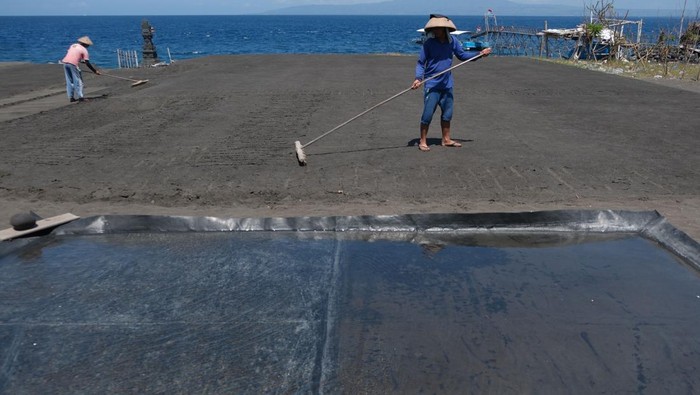 Petani mencari air laut saat proses pembuatan garam di Pantai Kusamba, Klungkung, Bali.