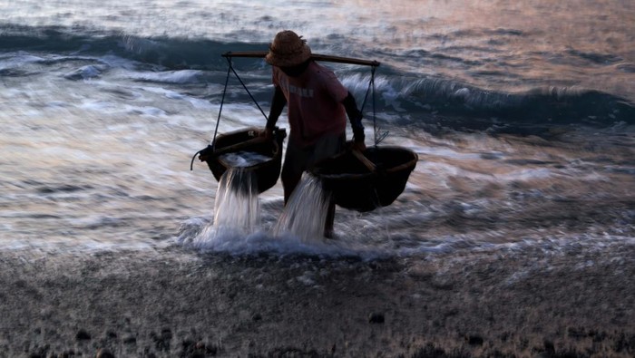 Produksi Garam khas Pantai Kusamba Bali Petani mencari air laut saat proses pembuatan garam di Pantai Kusamba, Klungkung, Bali.