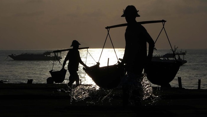 Petani mencari air laut saat proses pembuatan garam di Pantai Kusamba, Klungkung, Bali.