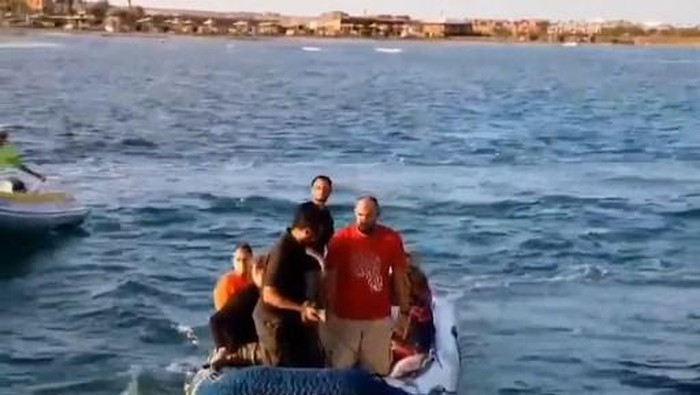 An image grab taken from a video made available by Egypts Red sea governors office on November 25, 2024 shows rescue workers helping tourists and crew members after a diving boat capsized in the Red Sea off Egypts coast. Rescuers recovered four bodies and three survivors on November 26, a day after a a boat capsized off of Egypts eastern coast, according to Red Sea governor Amr Hanafi, with nine people still missing. (Photo by Red Sea governors office / AFP) / RESTRICTED TO EDITORIAL USE - MANDATORY CREDIT 