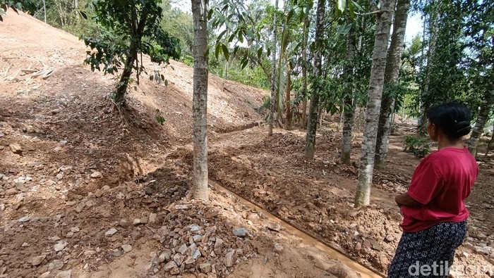 Warga terdampak longsor di Jering VI, Sidorejo, Godean, Sleman sedang melihat sisi samping rumah yang berbatasan langsung dengan lokasi calon perumahan, Selasa (26/11/2024).