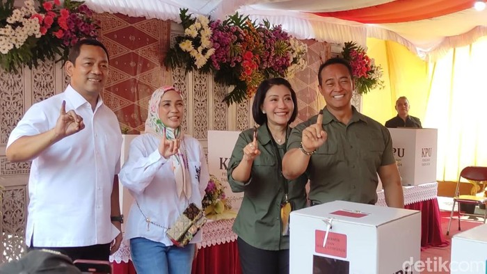 Andika-Hendi dan istri menunjukkan jari bertinta ungu di TPS 3 Lempongsari, Rabu (27/11/2024).