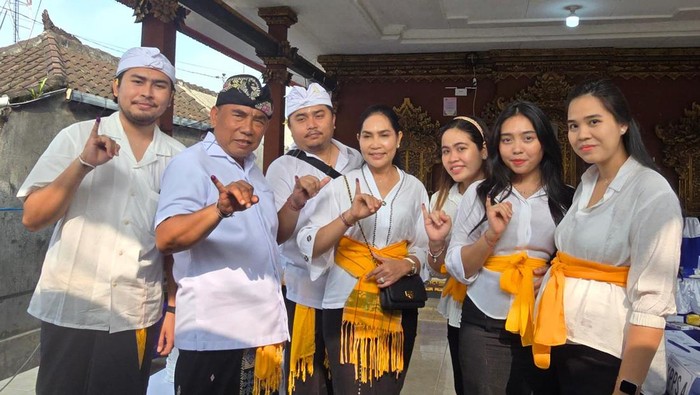 Cabup Jembrana nomor urut 01, I Nengah Tamba, mencoblos di TPS 008, Banjar Peh, Desa Kaliakah, Kecamatan Negara, didampingi seluruh keluarganya yang kompak berpakaian adat bali nuansa putih, Rabu (27/11/2024). (Dok. Pemkab Jembrana)