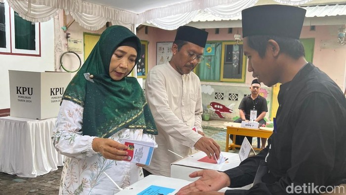 Calon gubernur NTB nomor urut 1 Sitti Rohmi Djalillah bersama suami, Muhammad Khairul Rizal,  mencoblos di TPS 06 Lingkungan Rakam, Kelurahan Selong, Lombok Timur, Rabu (27/11/2024).