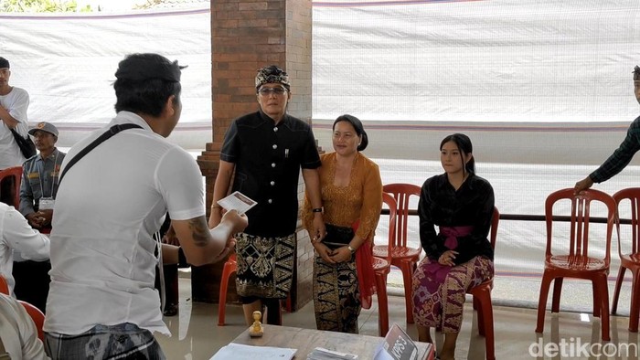 Cawagub Bali nomor urut 2, I Nyoman Giri Prasta, saat mencoblos bersama istri Ni Kadek Seniasih dan anak bungsunya Ni Komang Sundari Dewi, di  TPS 001, Desa Pelaga, Kecamatan Petang, Badung, Bali, Rabu (27/11/2024). (Foto: Agus Eka/detikBali)