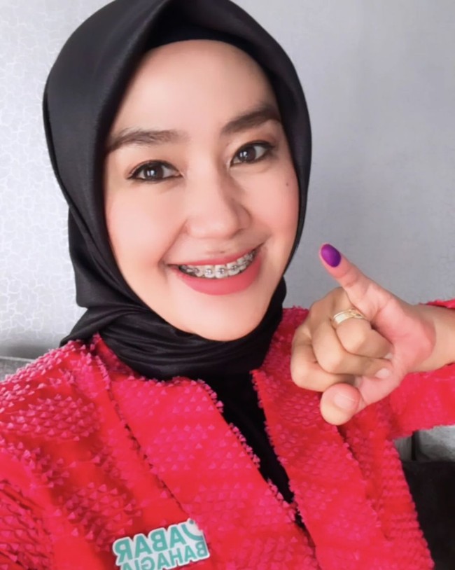 Penyanyi dangdut Gita KDI yang pada Pilkada 2024 menjadi calon wakil gubernur Jawa Barat mengunggah foto dirinya usai nyoblos. Gita terlihat memakai jilbab merah dan atasan merah. Foto: Dok. Instagram