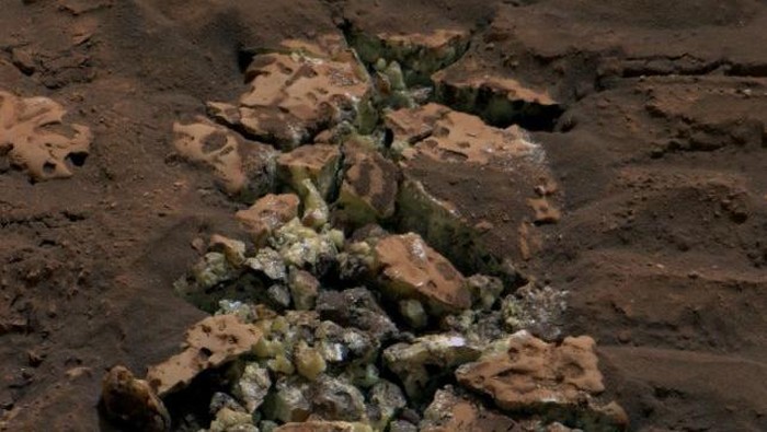 Sebuah batu di Mars menumpahkan harta karun mengejutkan setelah rover Curiosity milik NASA secara tidak sengaja memecahkan bagian luarnya yang terlihat biasa saja. Wahana penjelajah itu menggerakkan tubuhnya yang seberat 899 kg di atas batu, kemudian batu itu pecah dan memperlihatkan kristal kuning dari unsur belerang.