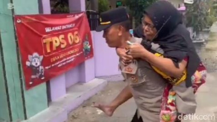 Kapolsek Ngimbang menggendong nenek untuk diantarkan ke TPS.